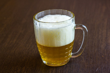 Mug of beer on wooden background