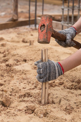 Worker hammering eucalyptus pointed