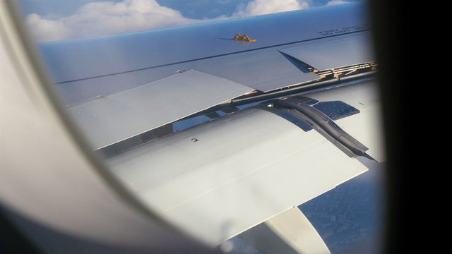 Airplane window view of the wings.