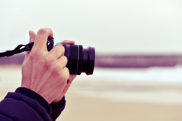 Fototapeta premium young man taking a picture in front of the sea