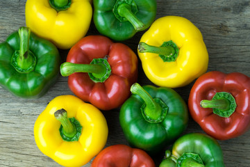 Colored bell peppers on wooden table