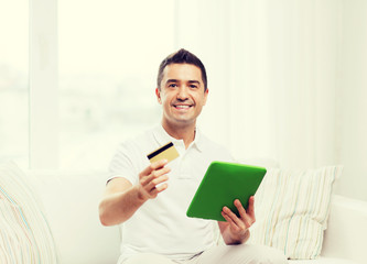 smiling man working with tablet pc at home