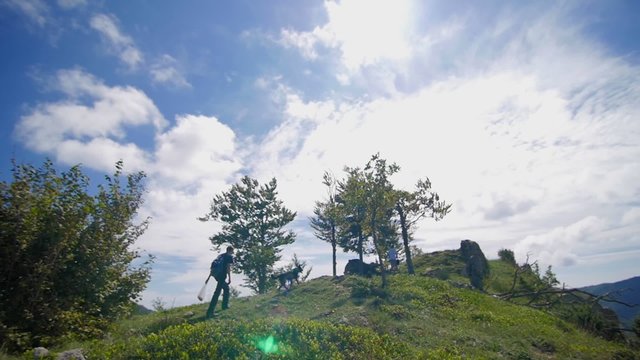 Slow motion of friends and dog on the top of a mountain