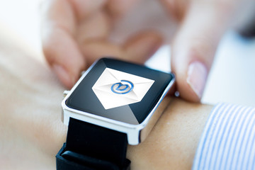 close up of hands with email icon on smartwatch