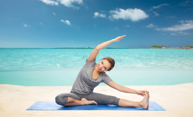 happy woman making yoga and stretching on beach 