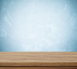 Empty wooden table over grunge cement wall background