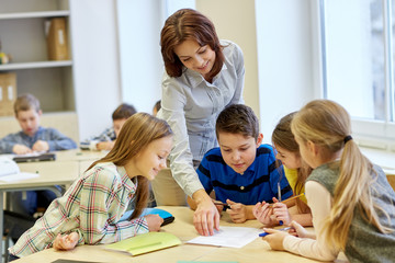 group of school kids writing test in classroom