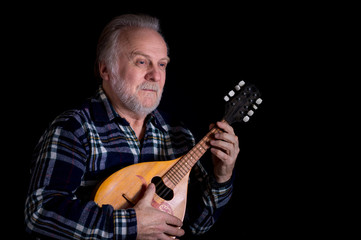 Portrait of bearded senior man with mandolin