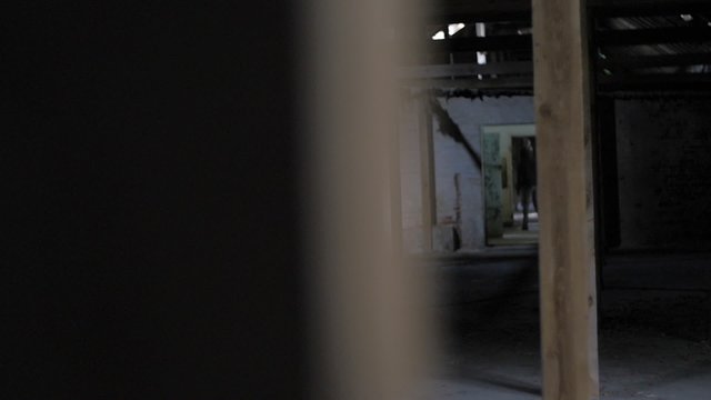 Slow motion of vandal with mask and bar running in abandoned building