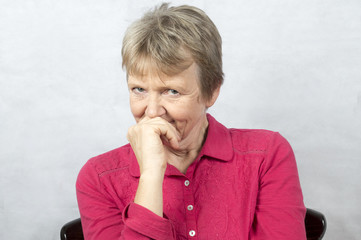 Portrait of a mature woman hiding a smile behind her hand 