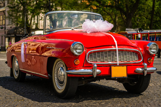 old retro car decorated with red ribbons and bow wedding