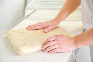 Close-up the hand of a baker kneading and shaping dough