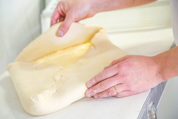 Close-up the hand of a baker kneading and shaping dough