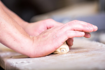 Close-up the hand of a baker kneading and shaping dough