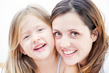 Closeup of a smiling young woman playing with her child on white background