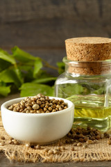 A white ceramic bowl full of hemp seeds and hemp oil, close up