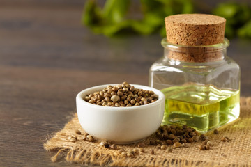 A white ceramic bowl full of hemp seeds and hemp oil, close up