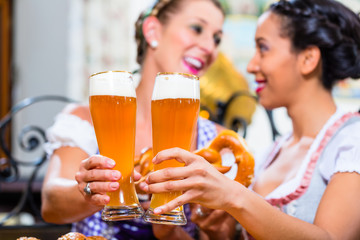 Women in Bavarian pub toasting with wheat beer
