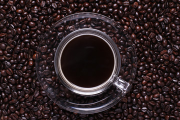 Coffee cup and coffee beans on wood background.