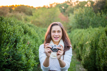 beautiful girl laughing in the park with a camera