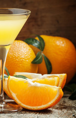 Yellow cocktail with orange juice in a martini glass, selective