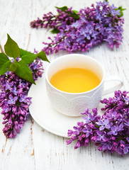 Cup of tea and lilac flowers
