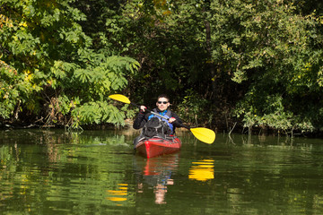 Men travel by canoe on the river in the summer.