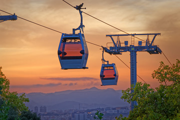 Cabin of cableway stands out Barcelona's sunset