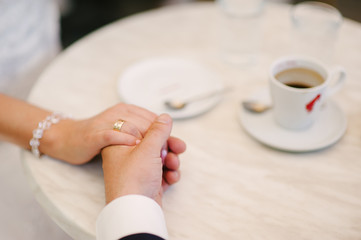 Bride and groom holding hands with wedding rings