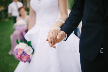 Obraz na płótnie Canvas Bride and groom holding hands