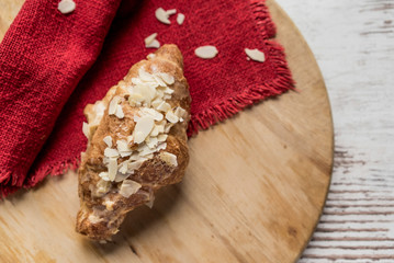 Almond croissant on a wooden board served for breakfast