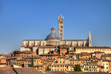 Fototapeta na wymiar The Cathedral of Siena on the skyline of the city in Tuscany, Italy. HDR