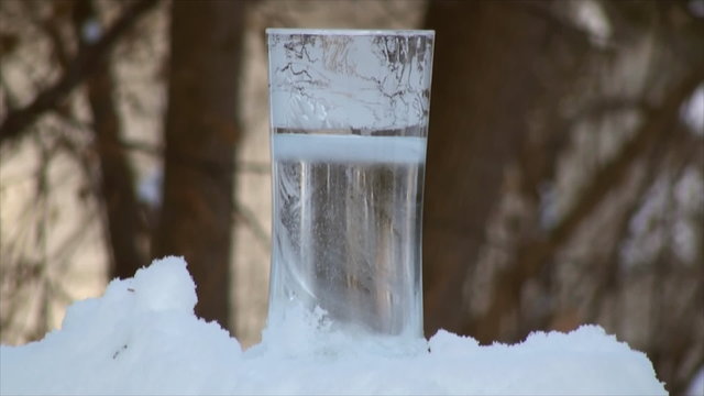 Freezing water in the thin tall glass in time lapse. Outdoor temperature was 6F.