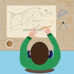 the engineer makes a drawing while sitting at table