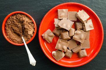 Chocolate bars with heap of cacao powder