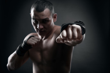 Fototapeta na wymiar Fighter boxer and warrior's fist on black background