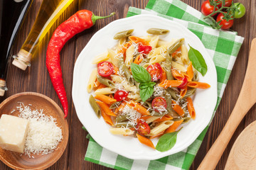 Colorful penne pasta with tomatoes and basil