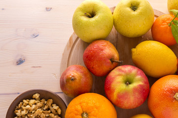 Fresh fruits and walnut on wooden board