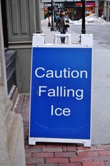 Obraz premium Caution falling ice sign on an icy sidewalk in Boston in winter