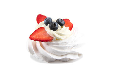 The Meringue cake with whipped cream and fresh blueberries, strawberries, isolated on white background.