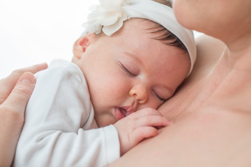 Closeup of a baby girl sleeping in her mother's arms © poplasen