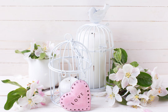 Spring apple blossom, candles in decorative bird cages and littl