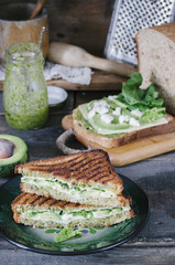 Healthy sandwich with cheese, pesto, avocado and spinach