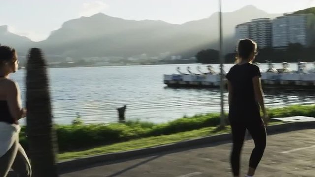Slow-motion tracking shot of people walking on a path beside Lagoa.