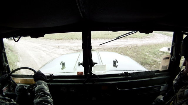 Troop transport in convoy training, driving on muddy road.