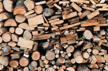 Stack of chopped firewoods prepared for winter. Wooden background