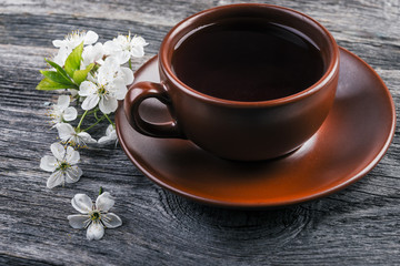   cup of tea with spring flower cherry blossom on a wooden rustic background.