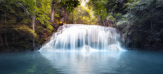 Cool fresh water pond in forest with smooth and silky waterfall cascades. Nature background panorama