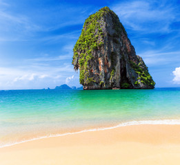 Naklejka premium Idyllic sandy empty beach with exotic mountain on sea water on Thailand cost