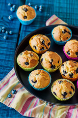 Muffins with blueberries. Summer dessert on a blue wood background